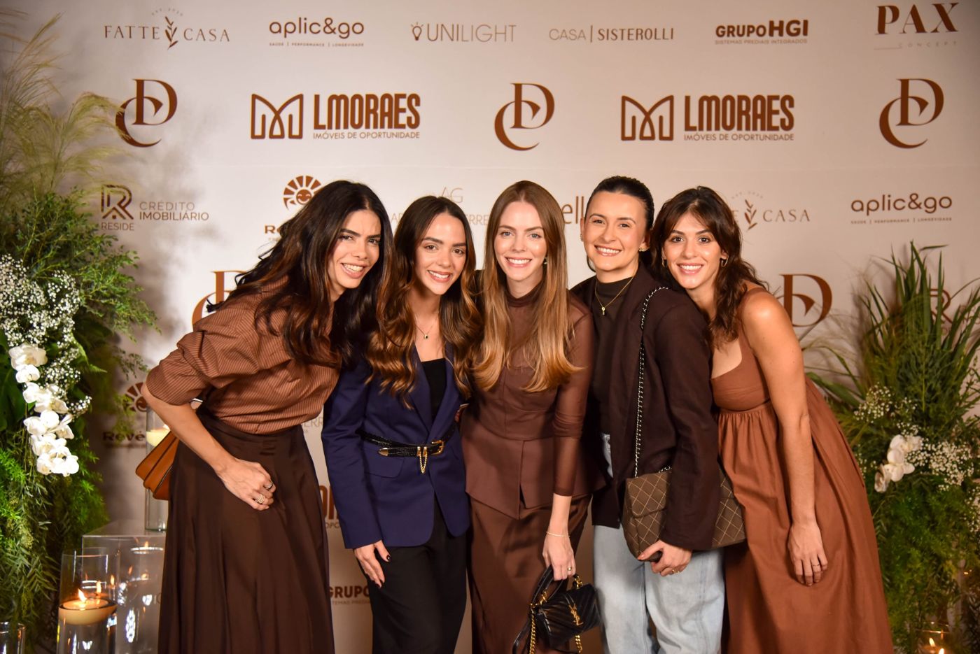 Cinco convidadas descontraídas no painel de fotos