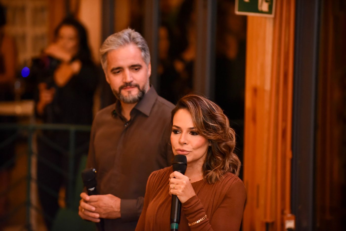 Anfitriões com microfone durante o evento
