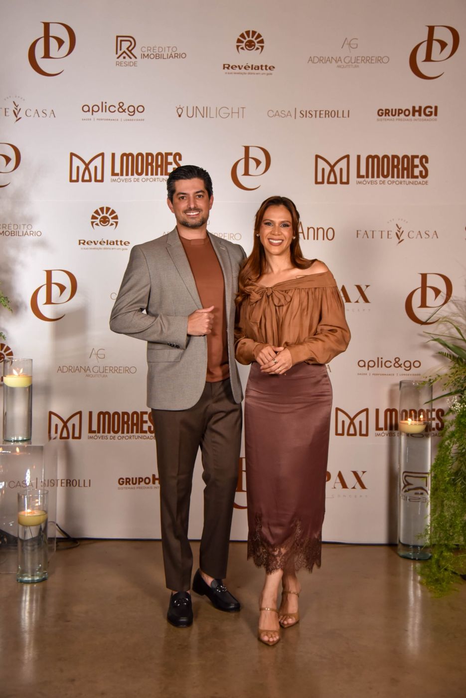 Casal de convidados posando no painel de fotos