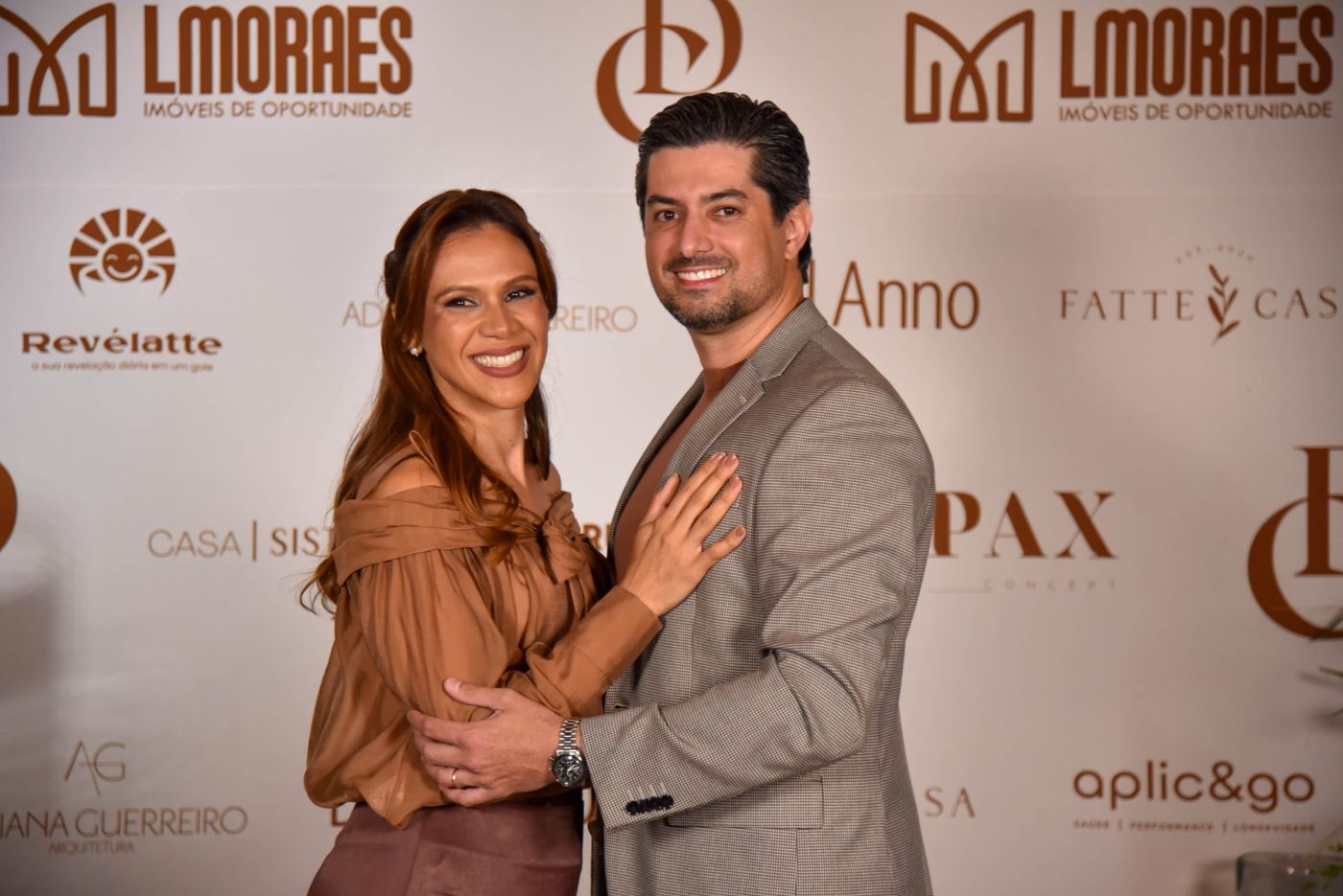 Casal abraçado sorrindo no painel de fotos